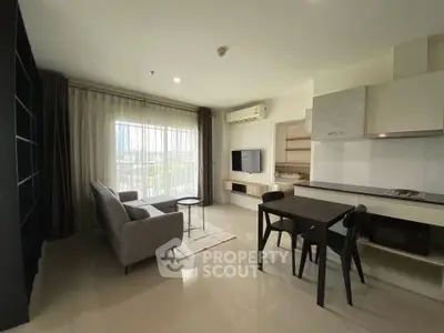 Modern living room with open kitchen, sleek furniture, and large window for natural light.