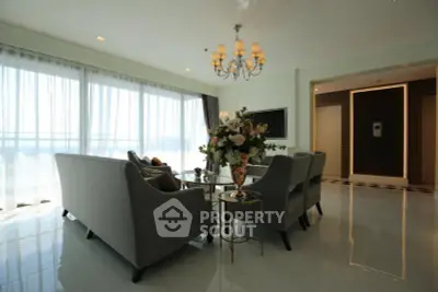 Elegant living room with chandelier and large windows offering natural light.