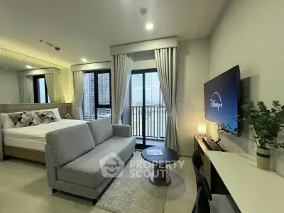 Modern studio apartment with balcony and city view, featuring stylish decor and a cozy living area.