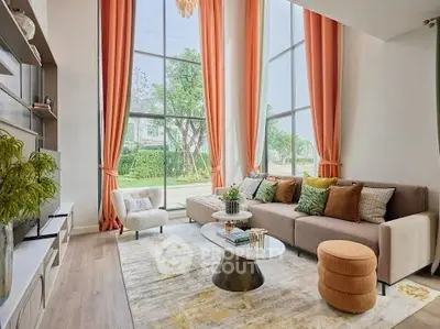 Luxurious living room with high ceilings, large windows, and elegant decor