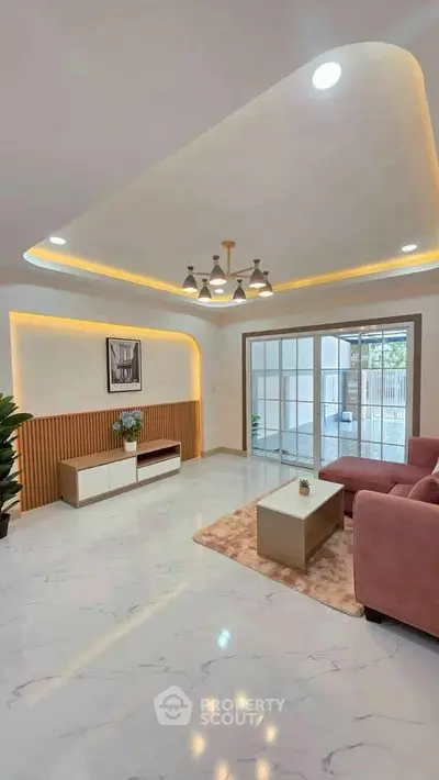 Elegant living room with modern lighting, pink sofa, and sliding glass doors leading to a balcony.