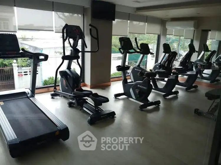 Modern gym with state-of-the-art fitness equipment and large windows for natural light.