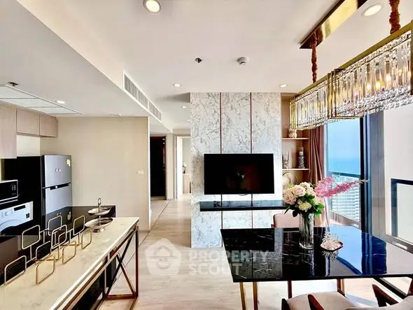 Luxurious modern living room with ocean view, elegant decor, and open kitchen layout.