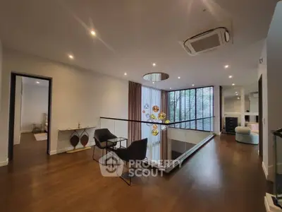 Spacious modern living area with elegant lighting and hardwood floors