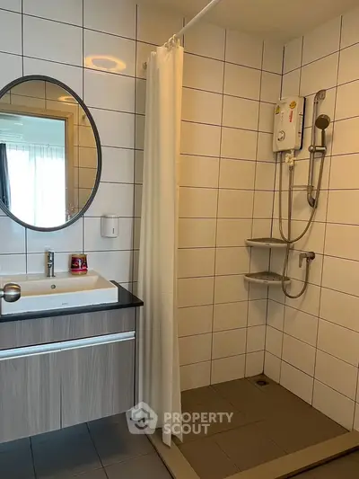 Modern bathroom with sleek vanity and shower area in contemporary apartment.