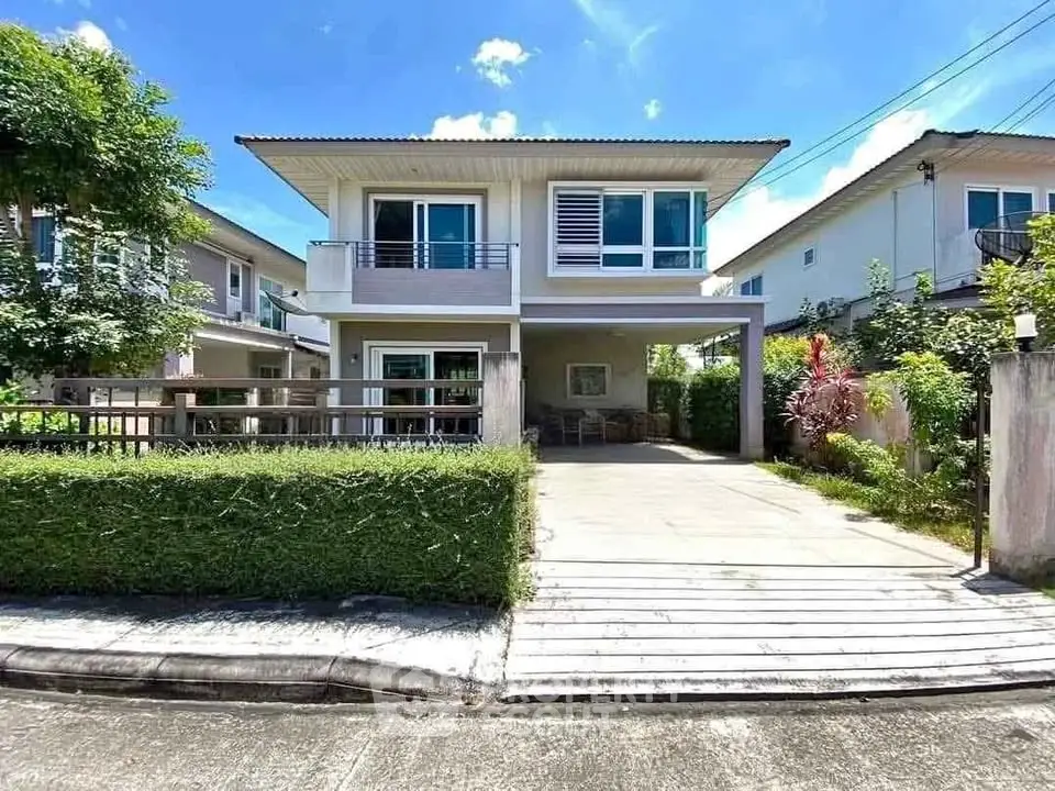 Modern two-story house with spacious driveway and lush greenery