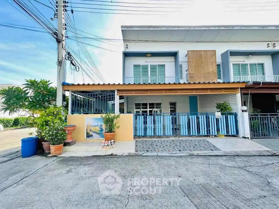 Charming townhouse with blue accents and spacious front patio in a serene neighborhood.
