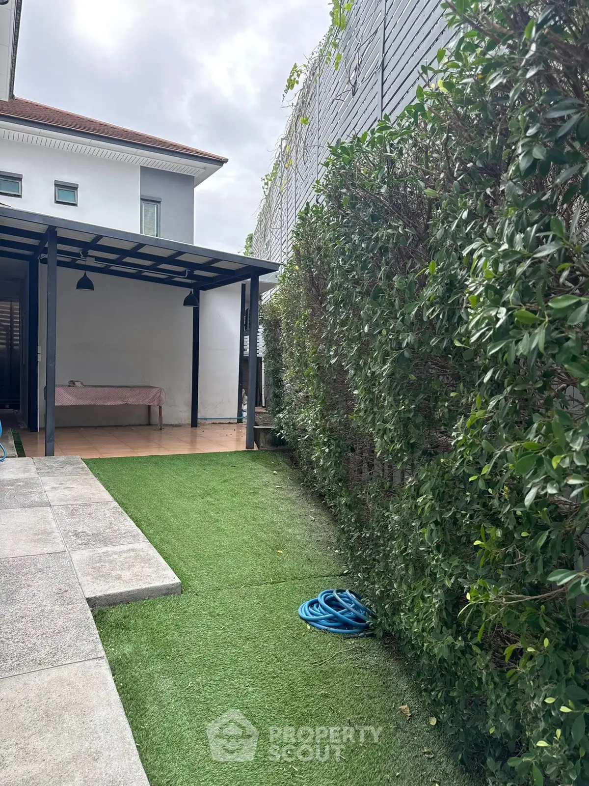 Charming garden area with lush greenery and modern patio, perfect for outdoor relaxation.