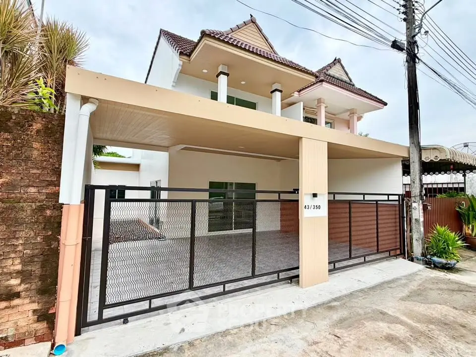 Charming two-story house with gated entrance and spacious carport in a serene neighborhood.