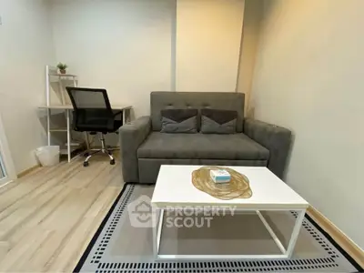 Cozy living room with modern sofa and desk, perfect for work and relaxation.