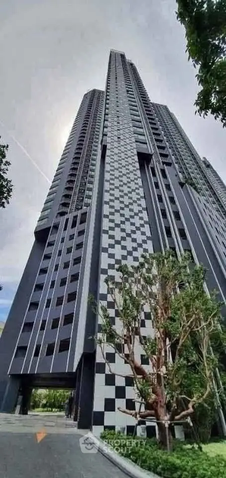 Stunning modern high-rise building with unique checkered facade and lush greenery
