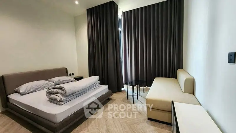 Modern bedroom with stylish furniture and elegant curtains in a cozy apartment.