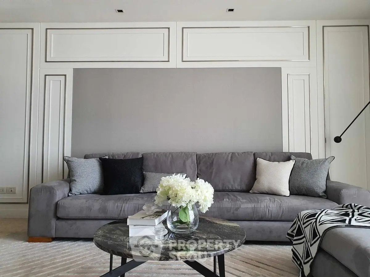 Elegant living room with modern gray sofa, stylish decor, and chic coffee table in a sophisticated setting.
