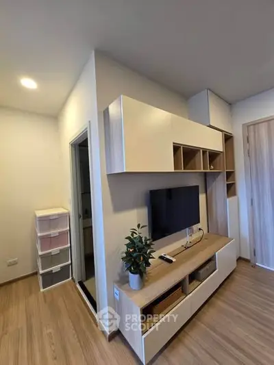 Modern living room with sleek wooden furniture and mounted TV, perfect for cozy relaxation.