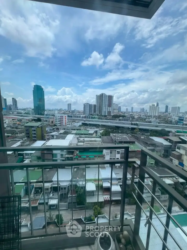 Stunning cityscape view from a high-rise balcony overlooking urban skyline and residential area.