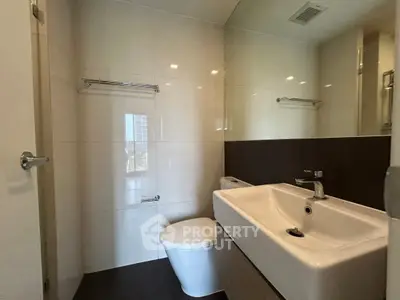 Modern bathroom with sleek fixtures and large mirror in a contemporary apartment.