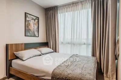 Cozy bedroom with modern decor and large window for natural light