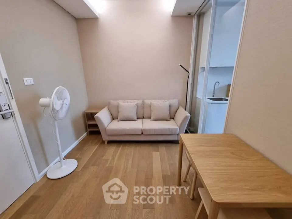 Cozy living room with modern decor and wooden flooring, featuring a comfortable sofa and a stylish floor lamp.