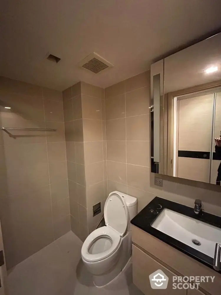 Modern bathroom with sleek fixtures and neutral tiles in a contemporary apartment.