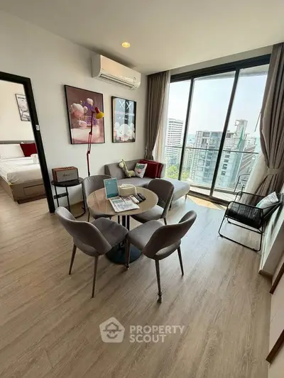 Modern living room with large windows and city view, featuring stylish furniture and decor.