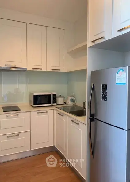 Modern kitchen with sleek white cabinets and stainless steel appliances