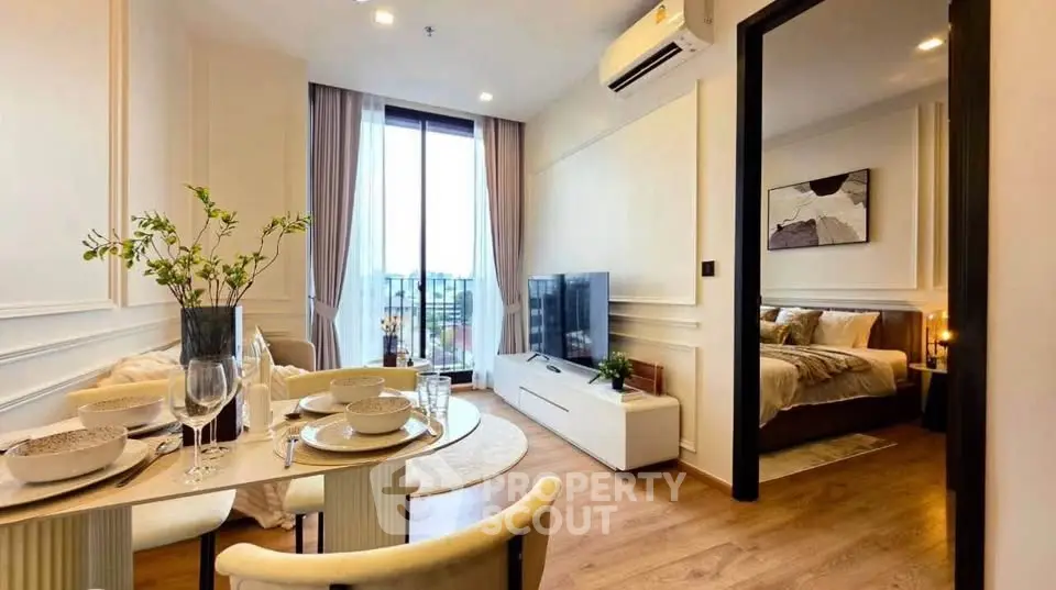 Modern open-plan living room with dining area and bedroom, featuring elegant decor and natural light.
