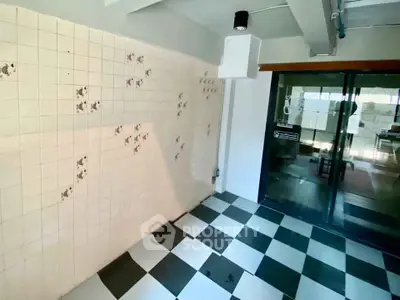 Charming tiled room with black and white checkered floor and glass sliding doors.