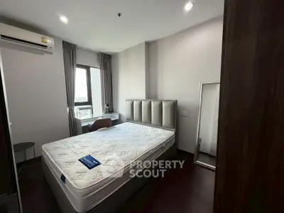 Modern bedroom with large window, stylish headboard, and sleek furnishings in a contemporary apartment.