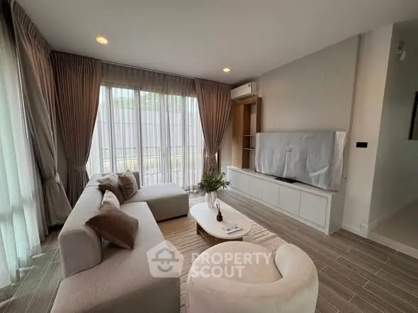 Modern living room with stylish furniture and large windows for natural light.