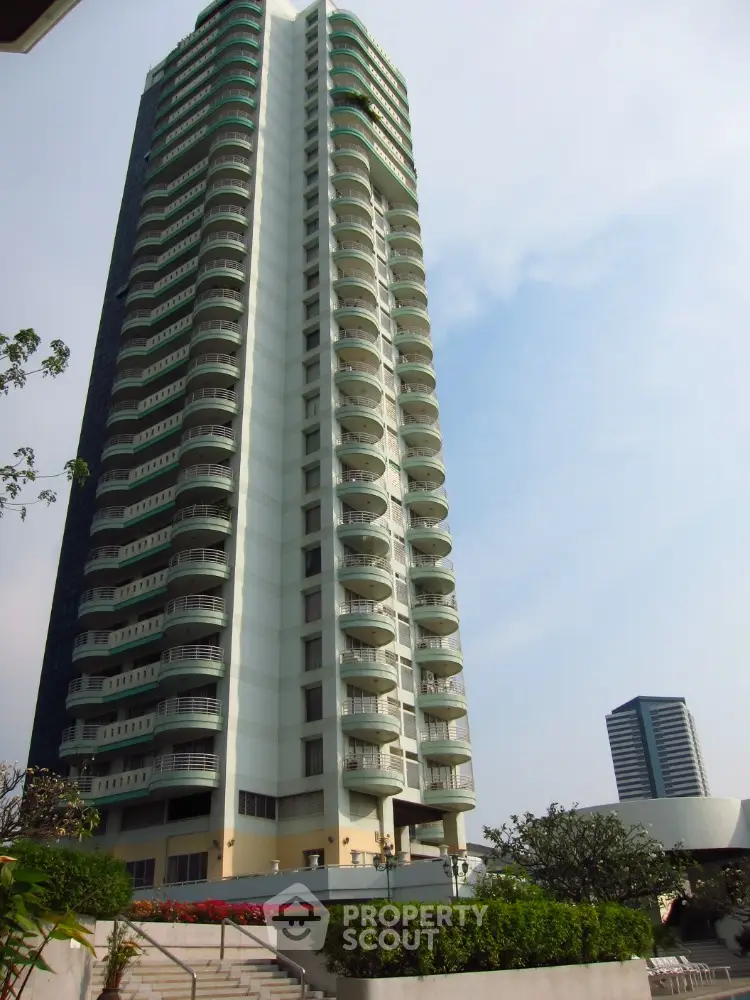 Stunning high-rise building with modern architecture and spacious balconies in urban setting.