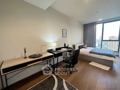 Modern bedroom with study area and city view, featuring sleek furniture and large window.