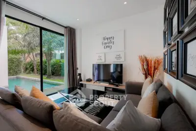 Luxurious living room with pool view, modern decor, and cozy seating area.
