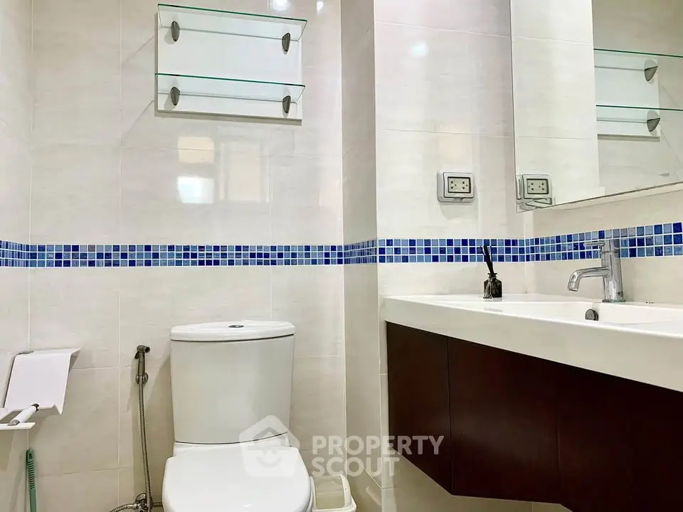 Modern bathroom with sleek fixtures and stylish blue tile accents