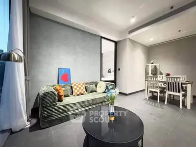 Modern living room with stylish decor and dining area, featuring a cozy sofa and elegant table setting.