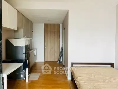 Modern studio apartment with wooden flooring and compact kitchen area.