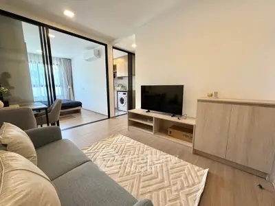 Modern living room with open layout and stylish decor, featuring a cozy sofa and entertainment center.