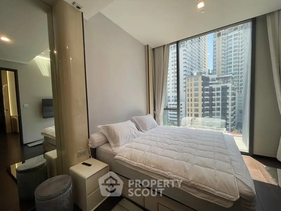 Luxurious bedroom with floor-to-ceiling windows offering stunning city views in a modern high-rise apartment.