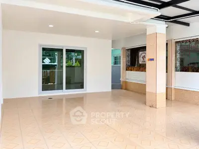 Spacious tiled balcony with sliding glass doors and covered roof, perfect for outdoor relaxation.