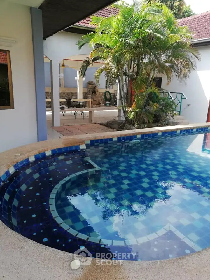 Stunning private pool area with lush greenery and elegant tile design, perfect for relaxation and entertainment.