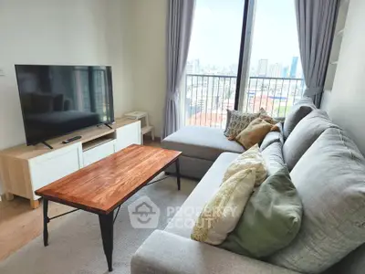 Modern living room with city view, featuring a cozy sofa, stylish coffee table, and large TV.