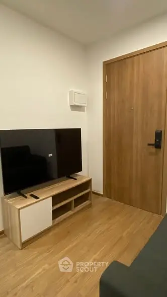 Modern living room with sleek TV setup and wooden flooring.