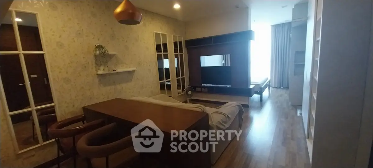 Stylish living room with modern decor and open layout, featuring a cozy seating area and elegant lighting.