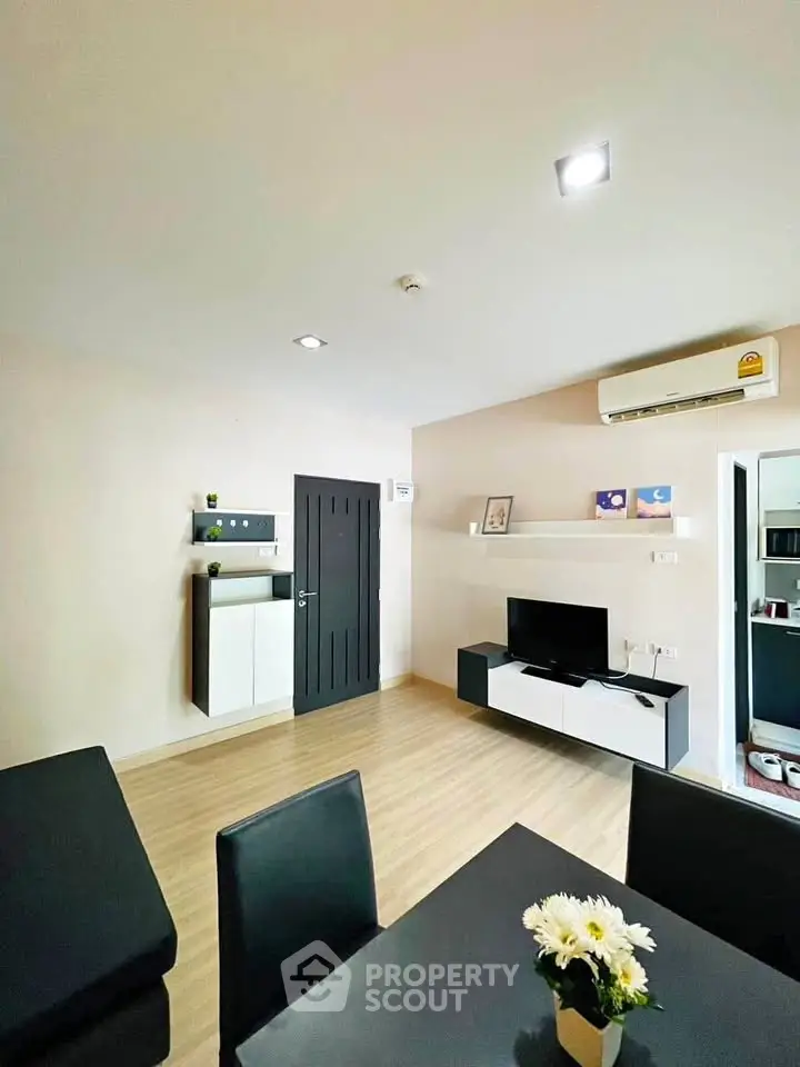 Modern living room with sleek furniture and wall-mounted TV in a cozy apartment.