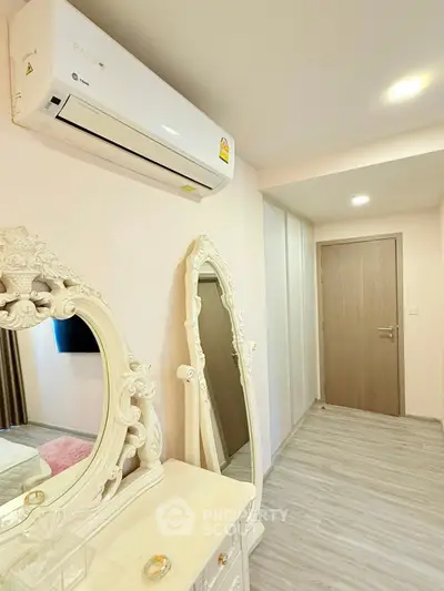 Elegant bedroom with ornate mirrors and air conditioning unit