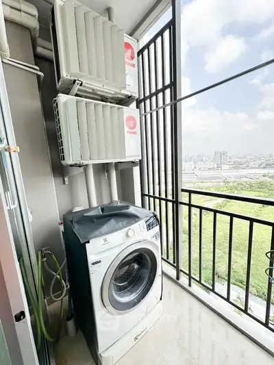 High-rise balcony with washing machine and city view, perfect for urban living.
