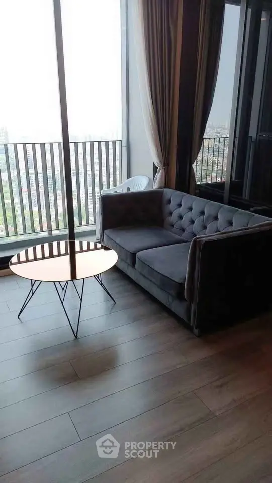 Stylish living room with modern sofa and city view from balcony