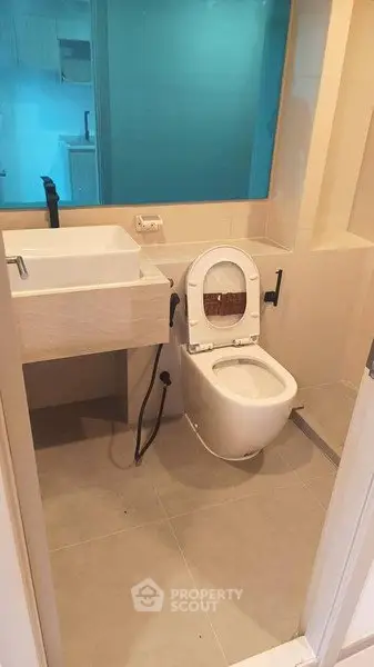 Modern bathroom with sleek fixtures and a glass partition for a contemporary look.