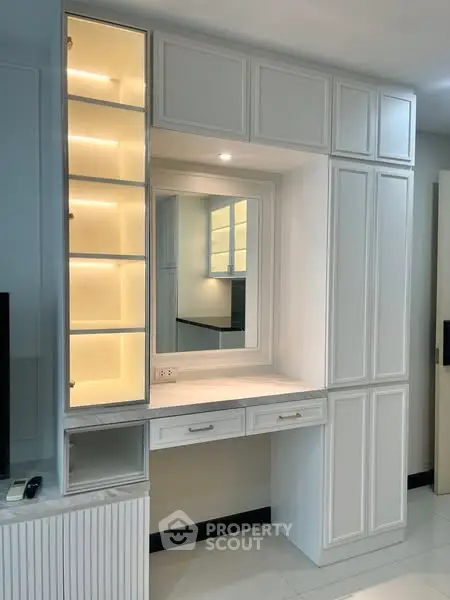 Elegant built-in storage unit with illuminated shelves and mirror in modern interior