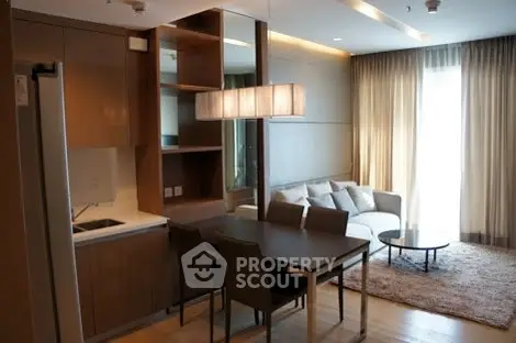 Modern living room with open kitchen, elegant dining area, and cozy seating in a stylish apartment.