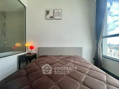 Modern bedroom with large window offering stunning city views and elegant decor.